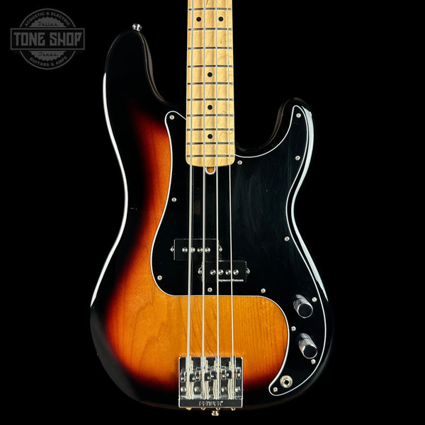 A classic Fender Stratocaster-style bass guitar with a sunburst finish, black pickguard, and maple neck, shown against a solid black background with a Tone Shop watermark in the top left corner.