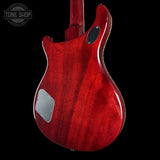 Red electric guitar body with a visible brand logo on a black background