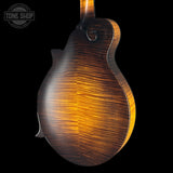 Close-up of a wooden mandolin back with 'Tone Shop' logo in the corner.