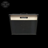 A Bad Cat guitar amplifier cabinet with a black grille and a cream-colored top panel, shown against a solid black background with a Tone Shop watermark in the upper left corner.