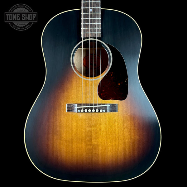 Acoustic guitar with a sunburst finish on a black background, featuring the Tone Shop logo.