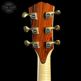Guitar headstock with tuning pegs on a black background, featuring the Taylor brand.