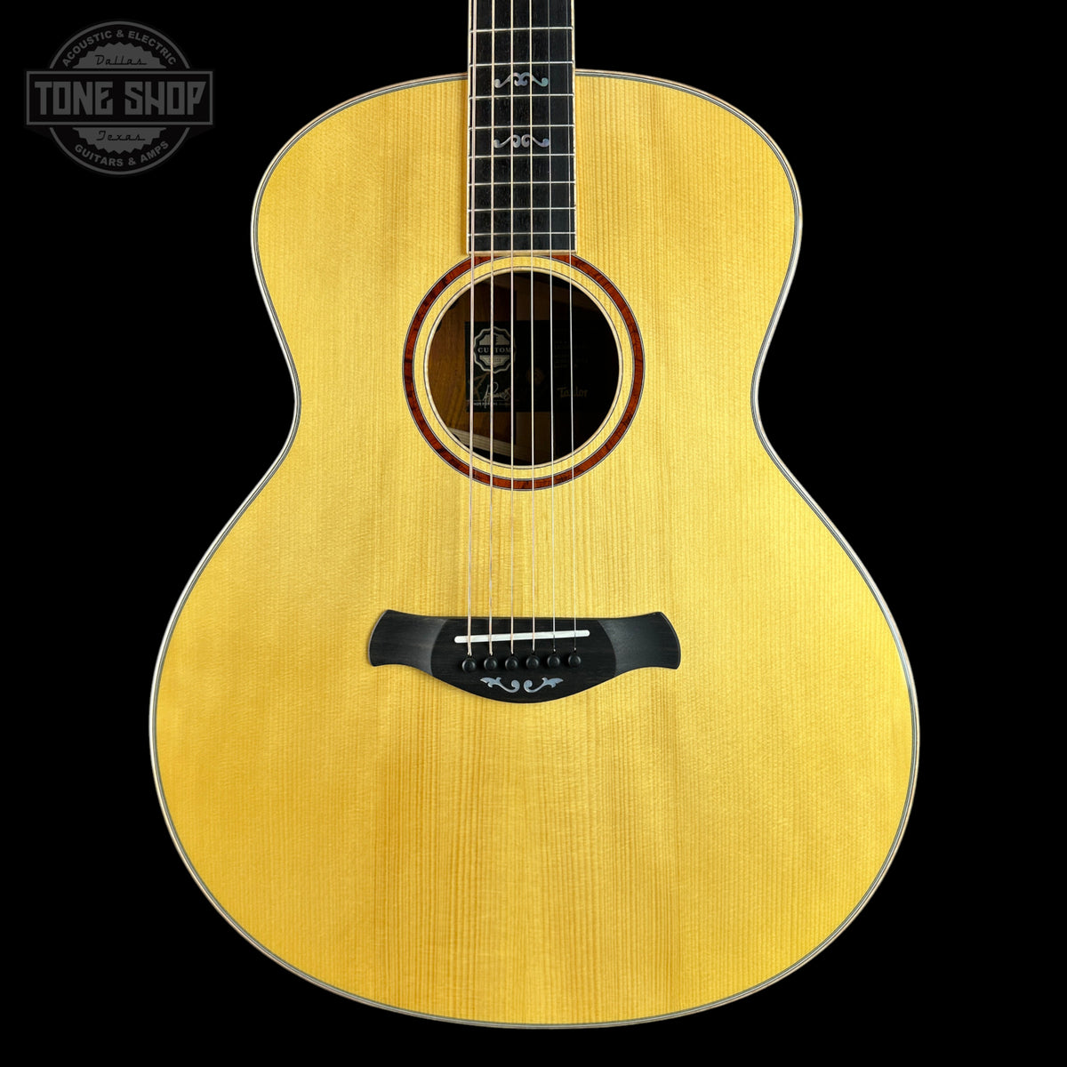Acoustic guitar with a visible brand logo on a black background