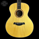 Acoustic guitar with a visible brand logo on a black background