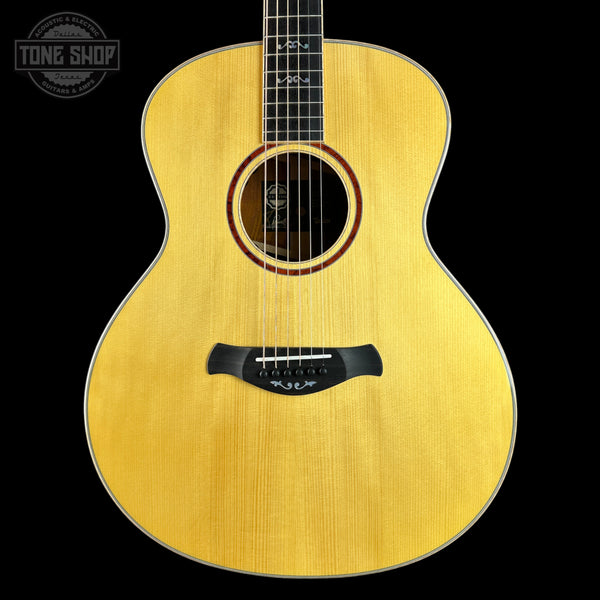 Acoustic guitar with a visible brand logo on a black background