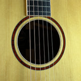 Close-up of a guitar's soundhole and strings on a beige background