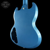 Blue electric guitar body with 'Tone Shop' logo in the corner