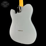 Back view of a silver electric guitar with a yellow strap on a black background, featuring the Tone Shop logo.