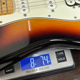 Guitar on a digital scale displaying weight