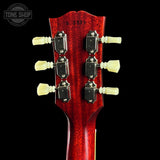 Close-up of a red guitar headstock with tuning pegs on a black background, featuring 'Tone Shop' branding.
