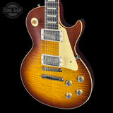 Gibson Les Paul electric guitar with a sunburst finish on a black background, featuring the Tone Shop logo.
