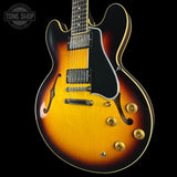 Electric guitar with a sunburst finish on a black background, featuring the Tone Shop logo.