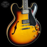 Electric guitar with a sunburst finish on a black background, featuring the Tone Shop logo.