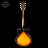 Back view of a guitar with a visible brand logo in the corner.