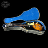 Guitar in a clear case with blue interior on a black background, featuring 'Tone Shop' logo.