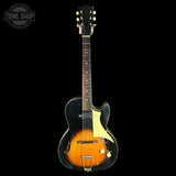 Vintage-style electric guitar with a black and orange design on a white background.