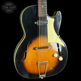 Vintage-style electric guitar with a black and brown finish on a black background, featuring the Tone Shop logo.