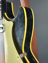 Close-up of a guitar's soundhole and headstock with a dark background