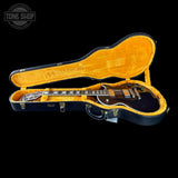 Guitar in an open case with a black interior, on a black background.