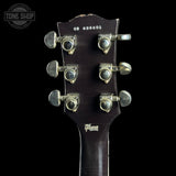 Gibson guitar headstock with tuning pegs on a black background