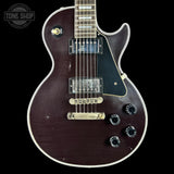 Electric guitar with a dark finish on a black background, featuring the 'Tone Shop' logo.