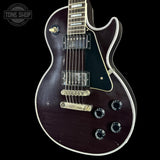 Electric guitar with a dark finish on a black background, featuring the 'Tone Shop' logo.
