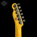 Close-up of a guitar headstock with tuning pegs on a black background, featuring the Tone Shop logo.