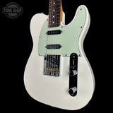 White electric guitar with a light green pickguard on a black background, featuring 'Tone Shop' branding.