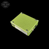 A lime green textured metal electronic box with silver screws and a white label, shown at an angle on a solid black background. A Tone Shop watermark is visible in the top-left corner.