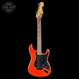 A classic electric guitar with a vibrant orange body, black pickguard, and maple neck, shown against a solid black background with a Tone Shop watermark in the top left corner.