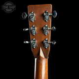 Close-up of a guitar headstock with tuning pegs on a black background, featuring the Tone Shop logo.