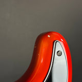 Close-up of the glossy red headstock of an electric guitar against a neutral gray background.