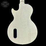 Back view of a white electric guitar with 'Tone Shop' logo.