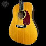 Acoustic guitar with a visible brand logo on a black background