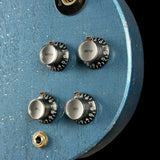 Close-up of a blue guitar headstock with control knobs and tuning pegs.