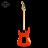 A Fender electric guitar shown from the back, featuring a vibrant orange-red glossy body, a natural maple neck, and chrome hardware, set against a solid black background with a Tone Shop watermark in the top-left corner.