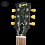 Gibson Les Paul guitar headstock with yellow tuning pegs on a black background