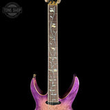 Purple electric guitar with a detailed neck on a black background, featuring 'Tone Shop' branding.