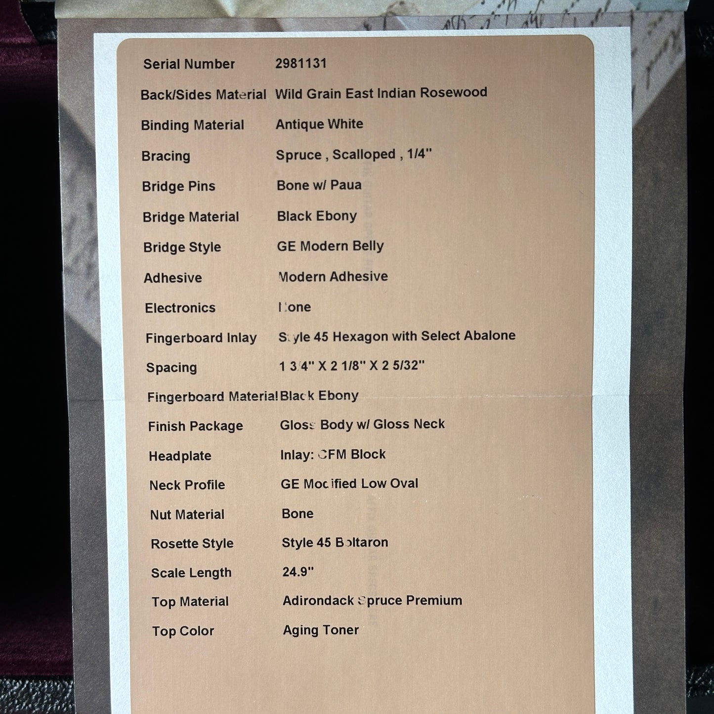 Technical specifications sheet for a guitar on a cardboard background