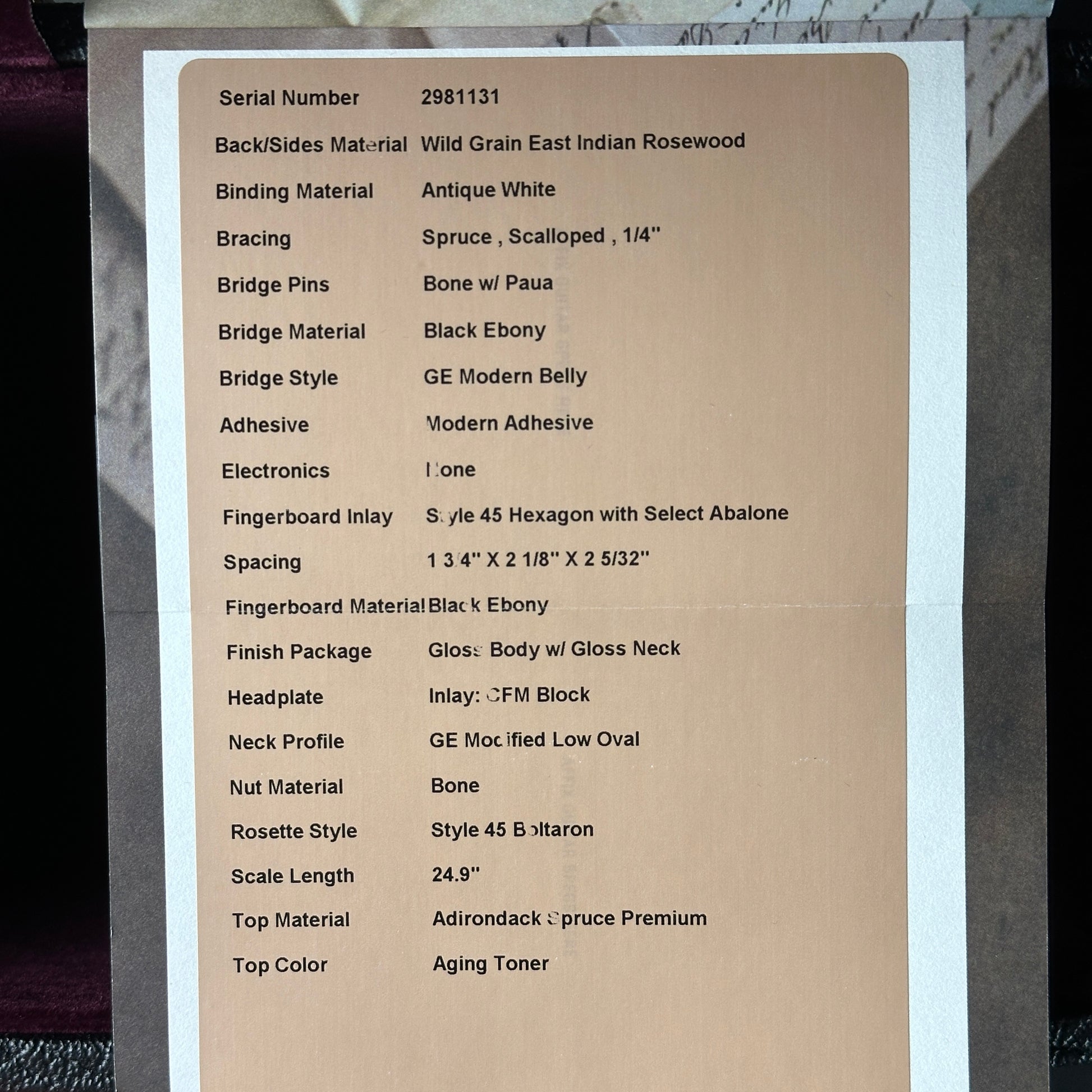 Technical specifications sheet for a guitar on a cardboard background