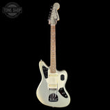 A silver metallic electric guitar with a maple neck, black pickguard, and cream-colored pickups, shown against a solid black background with a Tone Shop watermark in the top-left corner.