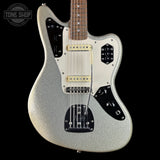 A silver glitter electric guitar with a white pickguard, black control plates, and gold hardware, shown against a solid black background. A Tone Shop watermark is visible in the top left corner.