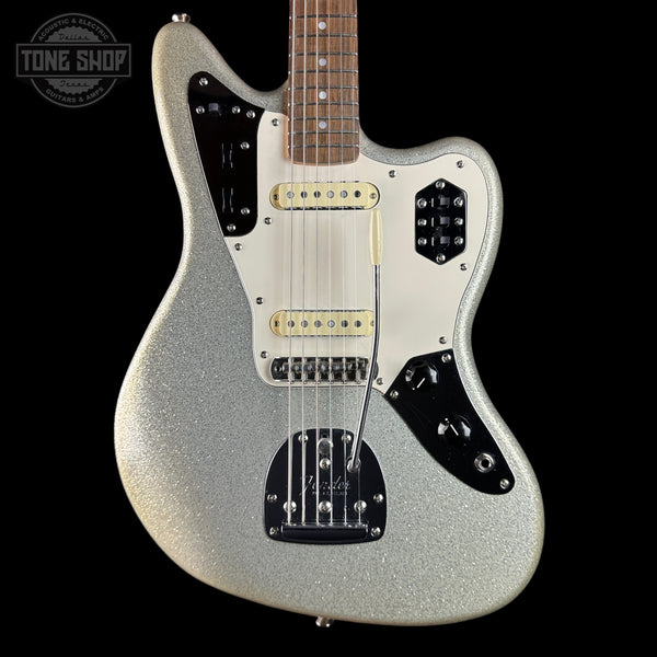 A silver glitter electric guitar with a white pickguard, black control plates, and gold hardware, shown against a solid black background. A Tone Shop watermark is visible in the top left corner.