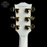 Gibson guitar headstock with tuning pegs on a black background