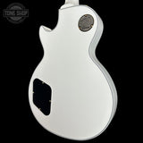 White electric guitar with Gibson logo on a black background
