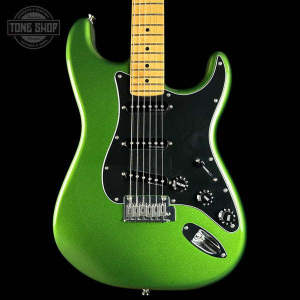 Green electric guitar with a black pickguard on a black background, featuring 'Tone Shop' branding.