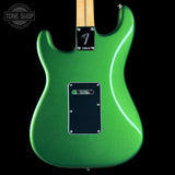 Green electric guitar with a visible brand logo on a black background