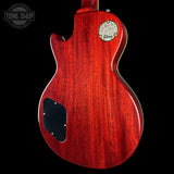 Red electric guitar body with a visible brand logo on a black background