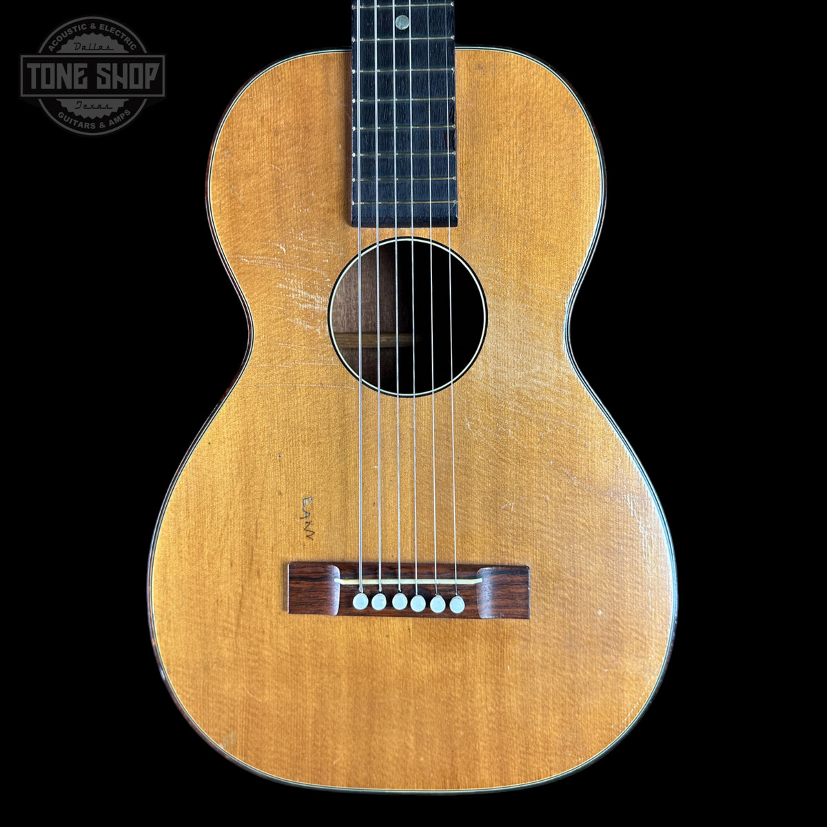 Acoustic guitar with a visible brand logo on a black background