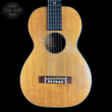 Acoustic guitar with a visible brand logo on a black background
